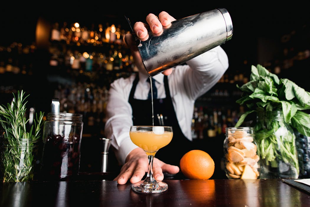 Mixologue préparant un cocktail dans un bar